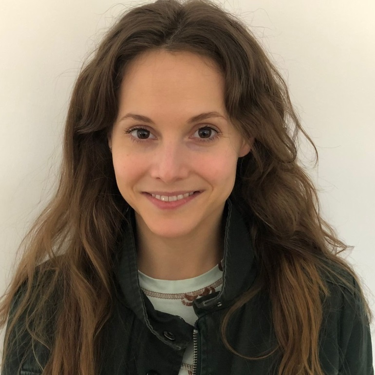 A picture of a brown-haired, brown-eyed woman smiling